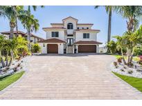 Stunning two-story home with a beautiful tiled roof, two car garages, a paved driveway, and lush landscaping at 16327 Redington Dr, Redington Beach, FL 33708