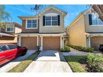 Inviting two-story townhouse featuring a two-car garage and well-maintained landscaping at 2028 Kings Palace Dr # 202, Riverview, FL 33578