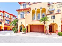 Mediterranean-style home with a two-car garage, arched entryway, balconies, and lush landscaping at 250 Seagate Ct, Dunedin, FL 34698