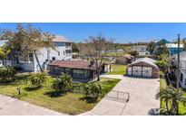 Charming single-story home with a gated entrance, well-manicured lawn, and unique garage at 5560 Frances Ave, New Port Richey, FL 34653