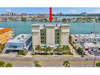 Beautiful condominium building with a view of the water and palm trees at 706 Bayway Blvd # 301, Clearwater Beach, FL 33767