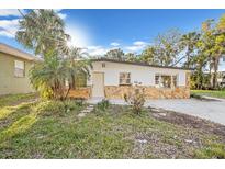 Charming single-story home featuring a stone facade and a well-maintained front yard with a palm tree at 7301 S Swoope St, Tampa, FL 33616