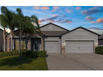 Charming single-story home featuring a stone facade and a spacious two-car garage at 11432 Leland Groves Dr, Riverview, FL 33579