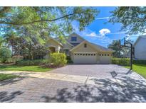 Charming home featuring a three car garage, manicured lawn and a brick paved driveway at 16318 Palmettoglen Ct, Lithia, FL 33547