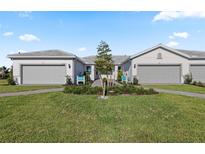 Charming single-story home features manicured lawn, gray garage doors, and welcoming landscaping at 25973 Bimini Sands Ct, Englewood, FL 34223