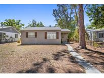 Charming single-story home with a stone walkway, natural shutters, and mature trees at 4218 2Nd S Ave, St Petersburg, FL 33711