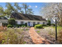 Charming one-story home with manicured lawn and brick walkway leading to a blue front door at 4520 W Rosemere Rd, Tampa, FL 33609