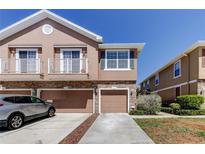 Charming townhome featuring a stone facade, private garages, and well-maintained landscaping under a bright, sunny sky at 565 52Nd N Ave, St Petersburg, FL 33703