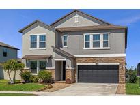 Charming two-story home with stone accents, manicured lawn, and a two-car garage at 8780 Flourish Dr, Land O Lakes, FL 34637