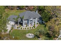 Stunning aerial view of a beautiful two-story home, showcasing its manicured lawn, fountain, and lush surroundings at 27625 Lincoln Pl, Wesley Chapel, FL 33544