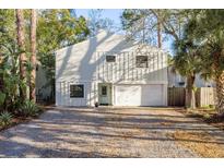 Charming two-story home featuring a light blue door and a spacious driveway at 314 Ontario Ave, Crystal Beach, FL 34681