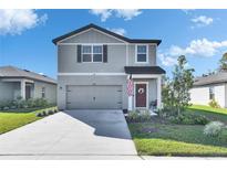 Charming two-story home with a well-manicured lawn and inviting front entrance at 9008 Waxwing Way, Parrish, FL 34219