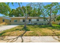 Charming single-story home featuring a well-maintained lawn and mature trees at 11114 Freedom Way, Seminole, FL 33772