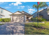 Charming single-story home featuring a brick driveway, manicured lawn, and an attached two-car garage at 12523 Longstone Ct, New Port Richey, FL 34655