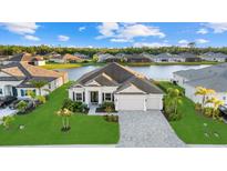 Stunning waterfront home with lush landscaping, paver driveway, and three-car garage at 15909 39Th E Gln, Parrish, FL 34219