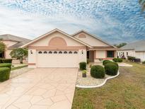 Charming single-story home with a well-manicured lawn, a two-car garage, and a beautifully patterned driveway at 1603 E Del Webb Blvd, Sun City Center, FL 33573
