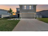 Beautiful two-story home featuring a two-car garage, neutral paint, and manicured front lawn at 16614 Mosaic Oar Dr, Wimauma, FL 33598