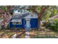 Charming blue home with white trim, complemented by mature landscaping and a welcoming entrance at 1700 30Th N Ave, St Petersburg, FL 33713