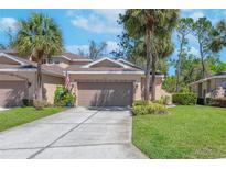 Charming home featuring a two-car garage, lush landscaping, and beautiful palm trees in the front yard at 2206 Preservation Dr # 2206, Plant City, FL 33566