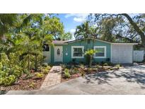 Charming curb appeal with a freshly painted home, brick pathway, and lush tropical landscaping at 4750 Burlington N Ave, St Petersburg, FL 33713