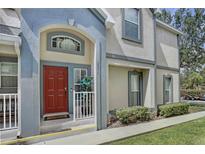 Inviting townhome exterior showcases a red front door and charming architectural details at 6036 Fishhawk Crossing Blvd, Lithia, FL 33547