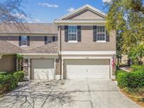 Inviting two-story townhome featuring a well-maintained yard and a two-car garage with a concrete driveway at 11240 Windsor Place Circle Cir, Tampa, FL 33626