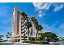 Elegant condo building showcasing coastal living with palm trees against a clear blue sky at 1270 Gulf Blvd # 506, Clearwater Beach, FL 33767