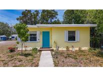 Charming yellow home with a vibrant blue door and a well-maintained front yard at 1679 29Th N Ave, St Petersburg, FL 33713