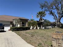 Beautiful single-story home with mature landscaping, brick accents, and a spacious driveway at 2405 Clubhouse Dr, Plant City, FL 33566