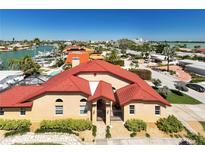 Beautiful waterfront home boasts vibrant red roof tiles and well-manicured landscaping in a desirable community at 2600 W Vina Del Mar Blvd, St Pete Beach, FL 33706