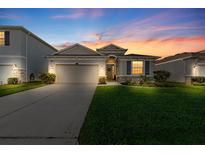 Charming single-story home featuring a well-manicured lawn, a two-car garage, and beautiful stone accents at 3097 Storybrook Preserve Dr, Odessa, FL 33556