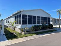 Charming single-story home featuring a lovely screened-in porch with tidy landscaping at 34510 Rose N Dr, Pinellas Park, FL 33781