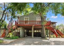 Charming elevated home featuring a wraparound porch, two staircases, and ample parking space below at 4508 Spring Rd, Valrico, FL 33596