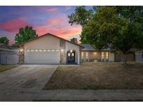 Charming single-story home with stone accents, double-door entry, manicured lawn, and attached two-car garage at 8329 Broken Willow Ln, Port Richey, FL 34668