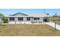 Charming single-story home with a well-manicured lawn and a driveway leading to a covered carport at 1021 Augusta Dr, Sun City Center, FL 33573