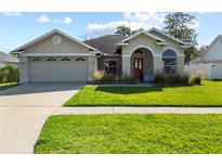 Charming single-story home featuring a well-manicured lawn, two car garage, and neutral exterior paint at 14916 Rocky Ledge Dr, Tampa, FL 33625