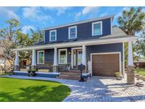 Charming blue two-story home with a welcoming front porch, beautiful stone accents, and well-manicured lawn at 2005 Jackson N St, St Petersburg, FL 33704