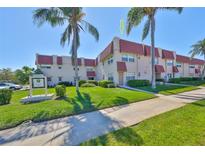 Well-maintained condo complex with lush landscaping and mature palm trees on a bright sunny day at 10038 62Nd N Ter # 21, St Petersburg, FL 33708