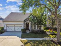 Charming single-Gathering home featuring a stone facade, manicured lawn, and two-car garage at 14605 Chatsworth Manor Cir, Tampa, FL 33626