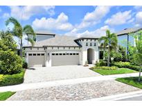 Charming two-story home with a three car garage, paver driveway and tropical landscaping at 14610 Red Castle Ave, Lithia, FL 33547