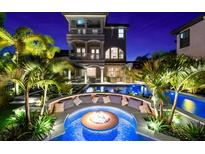 Backyard oasis with a fire pit, custom seating, a luxurious pool, and lush landscaping at 1550 Marinella Dr, Palm Harbor, FL 34683