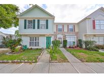 Charming two-story townhome with vibrant green door and well-maintained front yard at 1824 Mill Run Cir, Tampa, FL 33613