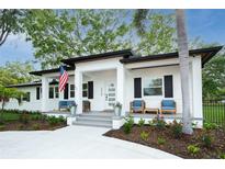 Charming single-story home featuring a welcoming front porch with an American flag at 3520 Poplar Ne St, St Petersburg, FL 33704