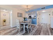 Charming dining room with updated floors, a modern light fixture, and stylish decor at 6372 Palma Del Mar S Blvd # 1007, St Petersburg, FL 33715