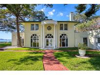 Stately two-story home featuring a manicured lawn, brick walkway, and classic architectural details at 800 Druid S Rd, Clearwater, FL 33756