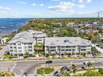 Stunning multi-Gathering building features a gray metal roof, balconies, and palm tree landscaping at 200 Main St # 202, Dunedin, FL 34698