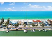 Stunning beachfront property with pristine sandy beach, turquoise water, and convenient dock access at 32 Gulf Blvd, Indian Rocks Beach, FL 33785