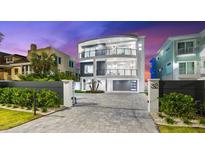 Modern, multi-story home with a sleek design, balcony views, and a paved driveway at 32 Gulf Blvd, Indian Rocks Beach, FL 33785