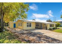 Charming yellow single-story home with a metal roof and a spacious driveway, perfect for a Gathering at 4509 26Th S Ave, Tampa, FL 33619