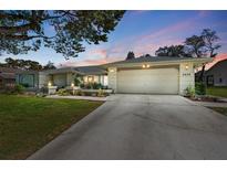 Charming single-story home featuring a well-manicured lawn and attached two-car garage at 5232 Kirkwood Ave, Spring Hill, FL 34608